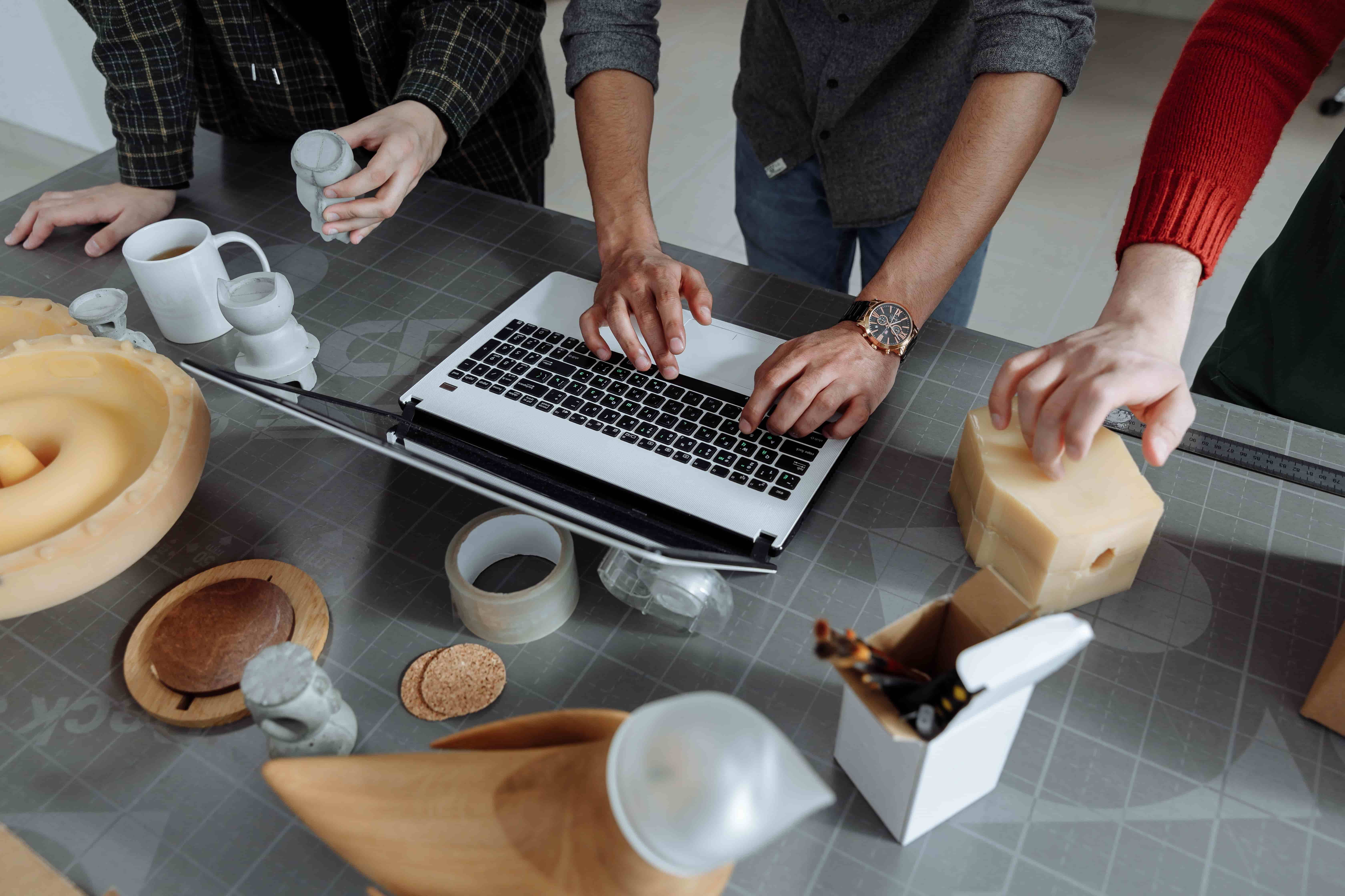A hands-on product team discussing prototypes around a laptop